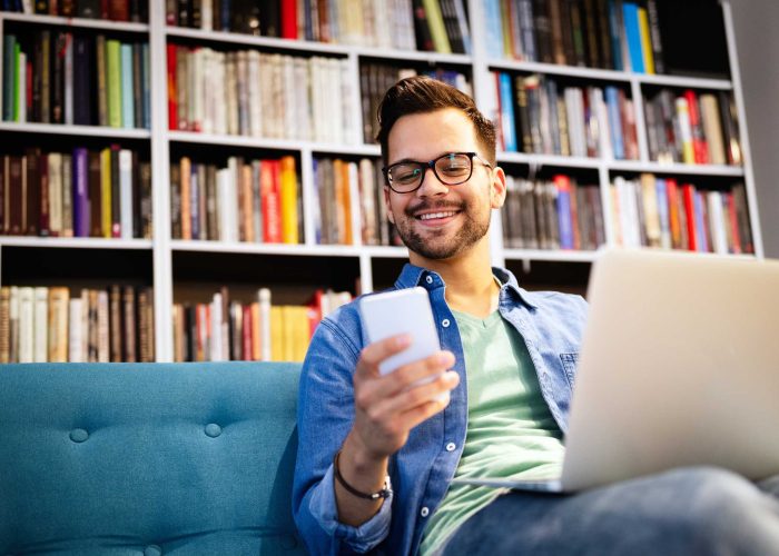 cheerful-smiling-man-talking-on-phone-and-working-RUUPQ67.jpg